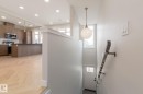 Modern kitchen featuring wood-finish cabinetry, stainless steel appliances, a large island with a dark countertop, and recessed lighting - 44 16231 19 Avenue, Edmonton, AB  - Indoor Photo Showing Kitchen With Upgraded Kitchen 