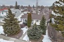 The property features a well-maintained exterior with a brown shingled roof, white siding, and a prominent bay window - 9813 152 Street, Edmonton, AB  - Outdoor 
