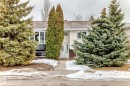 The property features a front facade with white-framed windows and a white front door, set back from a paved walkway - 9813 152 Street, Edmonton, AB  - Outdoor 