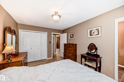 This room features neutral-toned walls, light-colored flooring, and a ceiling fan with an integrated light fixture - 9813 152 Street, Edmonton, AB - Indoor Photo Showing Bedroom