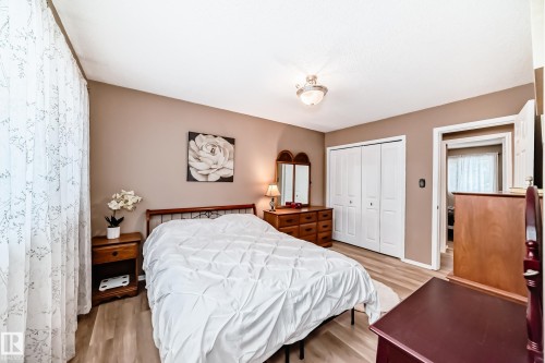 This bedroom features light wood-style flooring, neutral-toned walls, and a ceiling light fixture - 9813 152 Street, Edmonton, AB - Indoor Photo Showing Bedroom