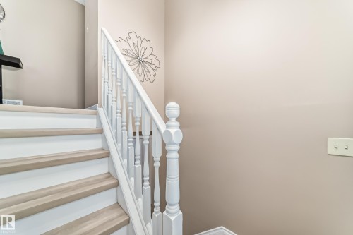 Staircase featuring white risers and light-toned wooden treads, complemented by a white banister and balusters - 9813 152 Street, Edmonton, AB - Indoor Photo Showing Other Room