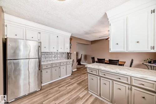 The kitchen features stainless steel appliances, light-colored upper cabinetry, and contrasting lower cabinetry - 9813 152 Street, Edmonton, AB - Indoor Photo Showing Kitchen