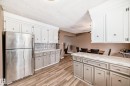 The kitchen features stainless steel appliances, light-colored upper cabinetry, and contrasting lower cabinetry - 9813 152 Street, Edmonton, AB  - Indoor Photo Showing Kitchen 