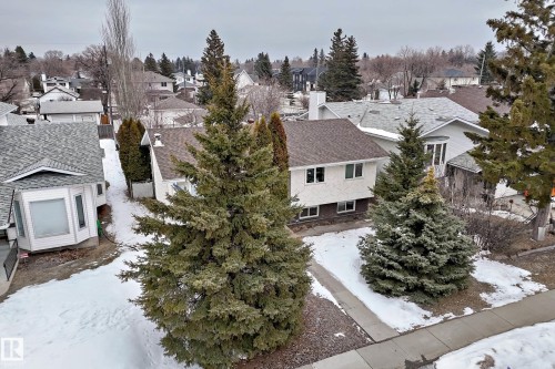 The property features a residence with a brown shingle roof, white siding, and visible windows on the lower level - 9813 152 Street, Edmonton, AB - Outdoor
