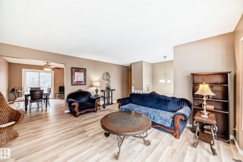 The property features light-toned flooring, a spacious entry, and a dining area with a glass sliding door - 9813 152 Street, Edmonton, AB - Indoor Photo Showing Living Room