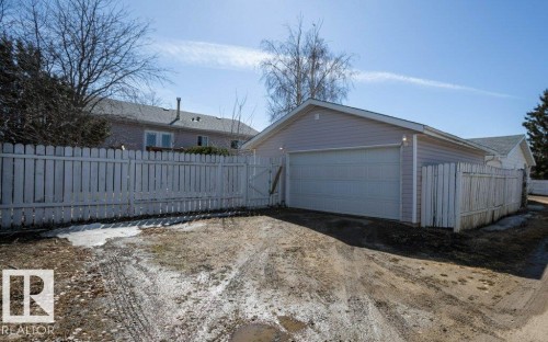 Detached garage with light-colored siding and an automatic overhead door - 10812 109 Street, Westlock, AB - Outdoor