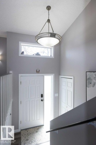 Entryway featuring a white panel door with sidelight, overhead transom window, and patterned tile flooring - 10812 109 Street, Westlock, AB - Indoor Photo Showing Other Room