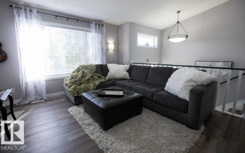 Living area featuring wood-finish flooring and neutral-toned walls - 10812 109 Street, Westlock, AB - Indoor Photo Showing Living Room