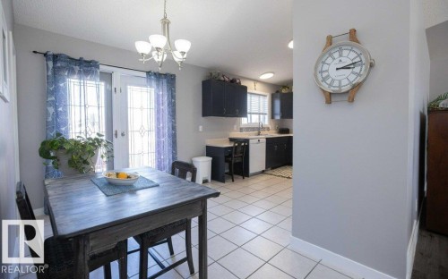 Dining area featuring tile flooring, a chandelier, and French doors with decorative glass inserts - 10812 109 Street, Westlock, AB - Indoor Photo Showing Dining Room