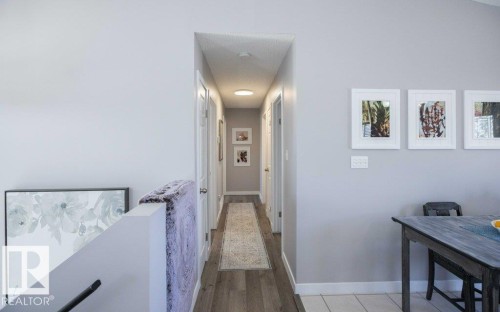 Hallway featuring wood-finish flooring, light grey painted walls, and white trim - 10812 109 Street, Westlock, AB - Indoor Photo Showing Other Room