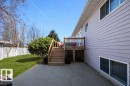 Exterior with light-colored horizontal siding, featuring a wood deck with stairs and lattice skirting - 10812 109 Street, Westlock, AB  - Outdoor With Deck Patio Veranda With Exterior 