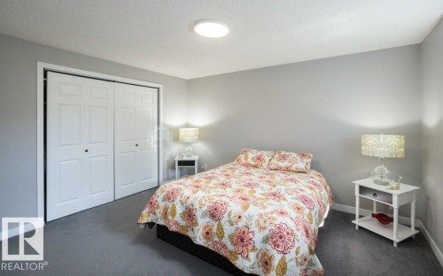 Bedroom featuring light gray walls, gray carpeting, and white bi-fold closet doors - 10812 109 Street, Westlock, AB - Indoor Photo Showing Bedroom