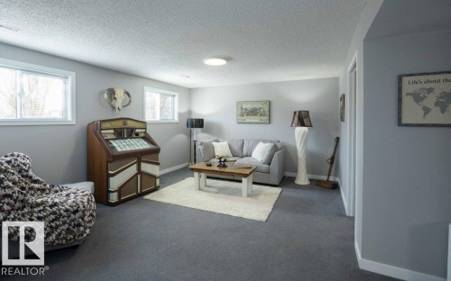 Carpeted entertainment area featuring light gray walls, white trim, and recessed lighting - 10812 109 Street, Westlock, AB - Indoor Photo Showing Living Room