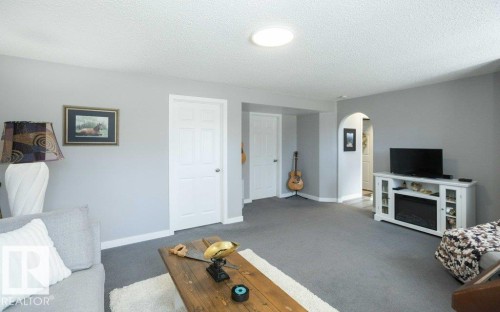 Spacious living area featuring light gray walls, gray carpeting, and white trim - 10812 109 Street, Westlock, AB - Indoor Photo Showing Other Room