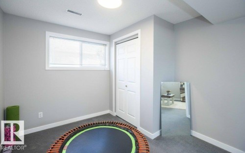 Room featuring light gray walls, white trim, a double bi-fold closet, and a white-framed window with blinds - 10812 109 Street, Westlock, AB - Indoor