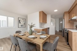 Open-concept living space featuring wood-finish flooring and ample natural light from the large windows - 