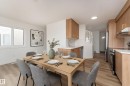 Open-concept living space featuring wood-finish flooring and ample natural light from the large windows - #63 1033 Youville Dr W Nw, Edmonton, AB  - Indoor 