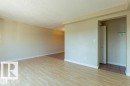 Open-concept living area featuring light wood-finish flooring and neutral painted walls - 307 8215 83 Avenue, Edmonton, AB  - Indoor Photo Showing Other Room 