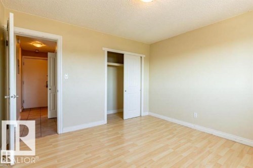 Spacious interior room with wood-finish flooring, light neutral wall paint, and white baseboards - 307 8215 83 Avenue, Edmonton, AB - Indoor Photo Showing Other Room