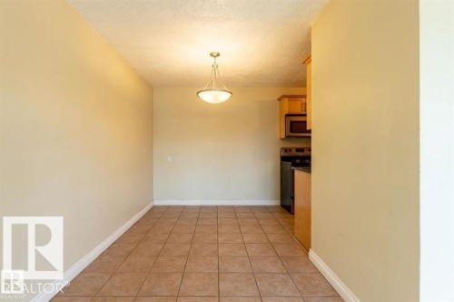 Dining area featuring ceramic tile flooring, a semi-flush mount light fixture, and neutral painted walls - 307 8215 83 Avenue, Edmonton, AB - Indoor Photo Showing Other Room