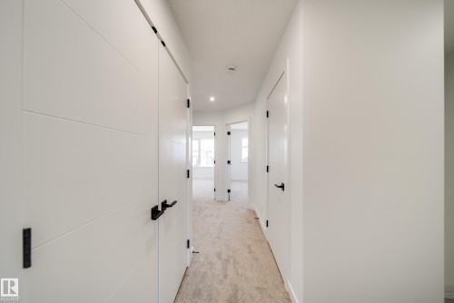 Hallway with light-colored carpet flooring and white walls - 92 Blackbird Bend E, Fort Saskatchewan, AB - Indoor Photo Showing Other Room