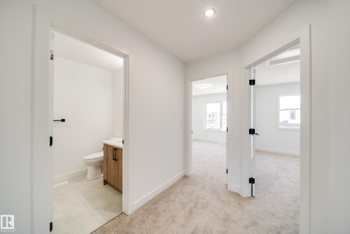Hallway featuring light-toned carpet flooring, recessed lighting, and white walls - 92 Blackbird Bend E, Fort Saskatchewan, AB - Indoor Photo Showing Other Room