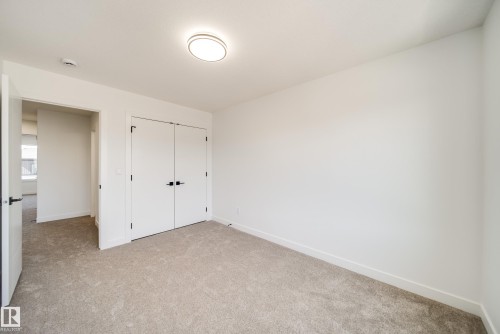 Neutral-toned carpet flooring - 92 Blackbird Bend E, Fort Saskatchewan, AB - Indoor Photo Showing Other Room
