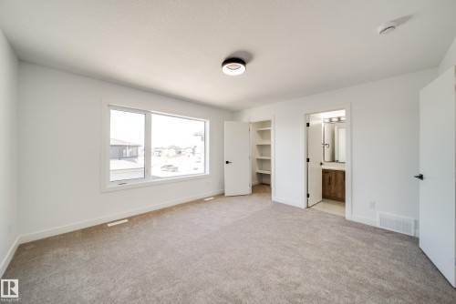 Spacious room featuring neutral carpet flooring and white painted walls - 92 Blackbird Bend E, Fort Saskatchewan, AB - Indoor Photo Showing Other Room