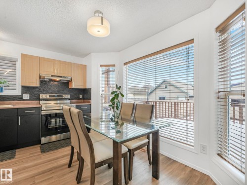 The property features a kitchen and dining area with hardwood floors and ample natural light from surrounding windows - 21360 88 Avenue, Edmonton, AB - Indoor