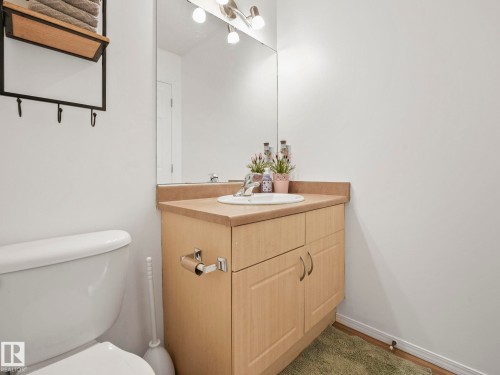 Bathroom featuring a vanity with a light wood cabinet, a white sink, and a large wall-mounted mirror - 21360 88 Avenue, Edmonton, AB - Indoor Photo Showing Bathroom