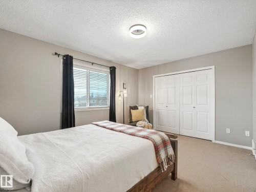 The room features a window with blinds, carpeted flooring, and a ceiling light fixture - 21360 88 Avenue, Edmonton, AB - Indoor Photo Showing Bedroom