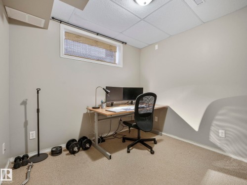 Room featuring light grey walls, light-colored carpeting, a drop ceiling, and a rectangular window with blinds - 21360 88 Avenue, Edmonton, AB - Indoor Photo Showing Office