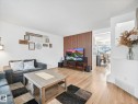 The living area features light wood flooring, white walls, and a modern wood slat accent wall - 21360 88 Avenue, Edmonton, AB  - Indoor Photo Showing Living Room 
