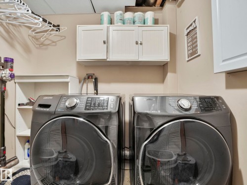 Laundry area with wall-mounted cabinetry and a hanging rack - 21360 88 Avenue, Edmonton, AB - Indoor Photo Showing Laundry Room