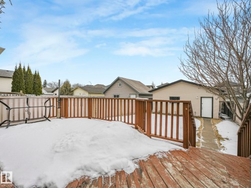 The property features a wooden deck with a railing and a paved walkway leading to an exterior building with siding - 21360 88 Avenue, Edmonton, AB - Outdoor