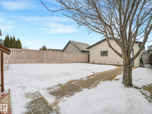 The property features a fenced yard, a detached building with siding, and a paved pathway - 21360 88 Avenue, Edmonton, AB - Outdoor