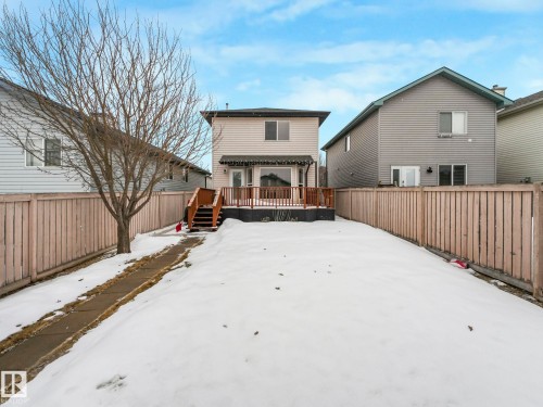 The property features a fenced yard, a wooden deck, and a bare tree - 21360 88 Avenue, Edmonton, AB - Outdoor With Deck Patio Veranda With Exterior
