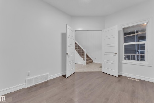 Room featuring wood-finish flooring, white baseboards, and a window with white trim - 3235 13 Avenue, Edmonton, AB - Indoor Photo Showing Other Room