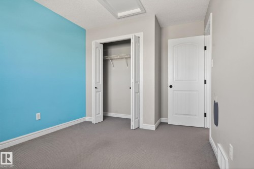Room featuring neutral gray carpeting and a contrasting blue accent wall - 332 Nelson Drive, Spruce Grove, AB - Indoor Photo Showing Other Room