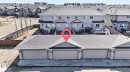 Rear exterior of a multi-unit property featuring a row of attached garages with individual doors - 332 Nelson Drive, Spruce Grove, AB  - Outdoor 