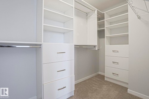 White custom closet system featuring multiple shelving units and integrated drawers - 4314 Cooke Lane, Edmonton, AB - Indoor With Storage