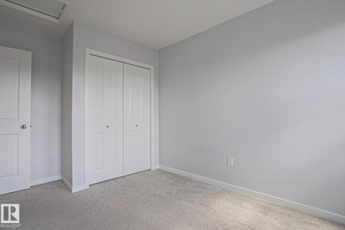Neutral toned room featuring plush carpet flooring, light gray wall paint, white trim, and a white bi-fold closet - 4314 Cooke Lane, Edmonton, AB - Indoor Photo Showing Other Room