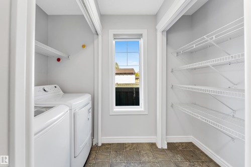 Dedicated laundry area featuring a window, tile flooring, and light gray walls - 1921 119A Street, Edmonton, AB - Indoor