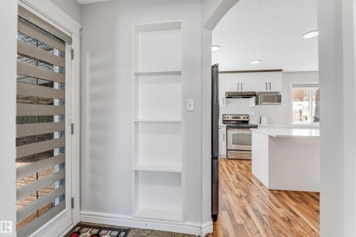 Entryway featuring built-in shelving, a full-lite door with privacy blinds, and tile flooring - 1921 119A Street, Edmonton, AB - Indoor