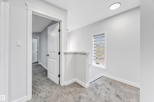 Upper-level landing featuring textured gray carpeting and light gray wall paint - 1921 119A Street, Edmonton, AB - Indoor Photo Showing Other Room
