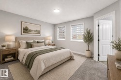 Spacious room featuring light gray wall tones, two windows with horizontal blinds, and neutral-toned carpeting - 