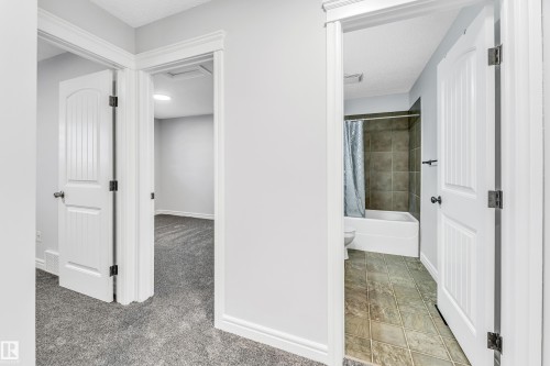 Bathroom with a full tub and shower, complemented by square floor tiling - 1921 119A Street, Edmonton, AB - Indoor Photo Showing Other Room