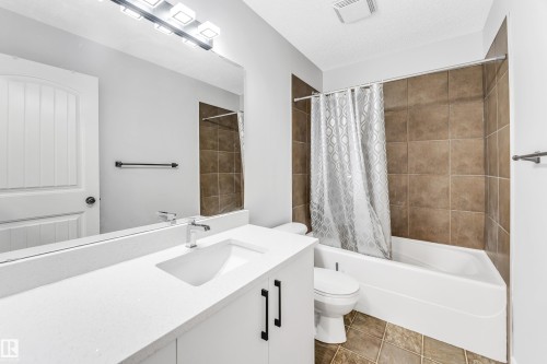 Bathroom featuring a white vanity with a single basin, a chrome faucet, and a large mirror - 1921 119A Street, Edmonton, AB - Indoor Photo Showing Bathroom