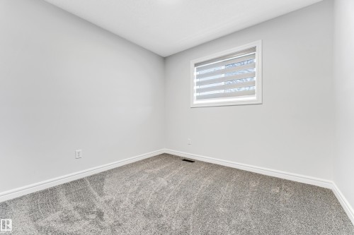 Room featuring light gray wall paint, gray patterned carpet, white baseboards, and a window with horizontal blinds - 1921 119A Street, Edmonton, AB - Indoor Photo Showing Other Room